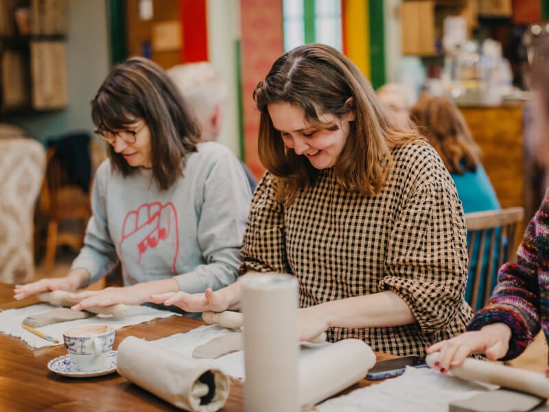 Women rolling clay 
